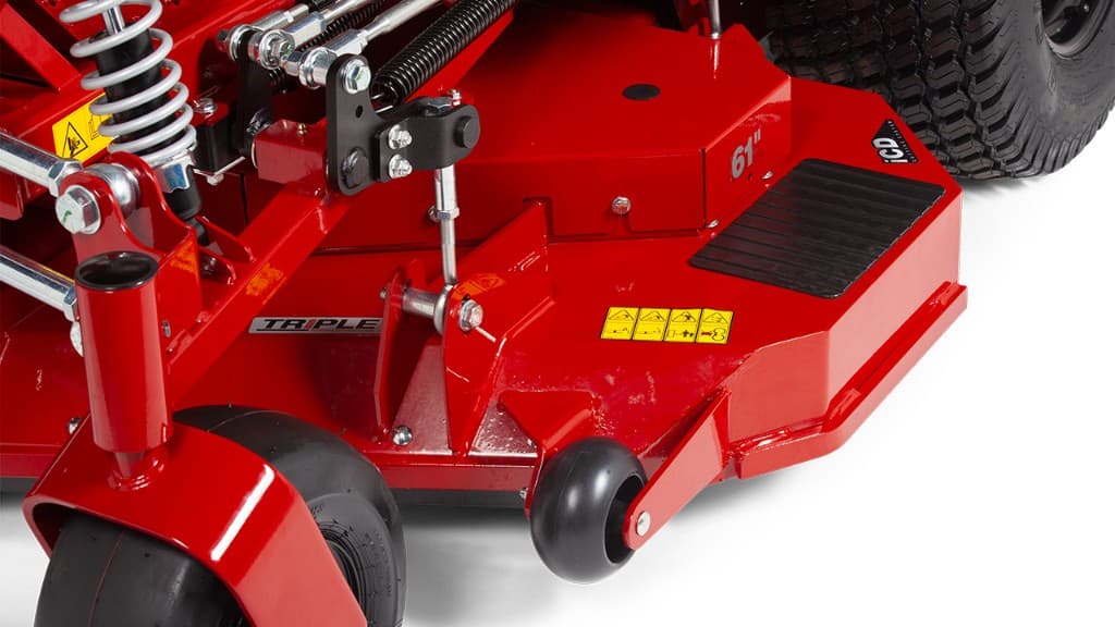 Close-up of Ferris independent suspension with coil-over shock, 61-inch iCD cutting deck, and triple-blade badges on a Ferris mower